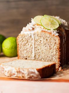 a loaf of key lime pound cake sitting on top of a cutting board next to two limes