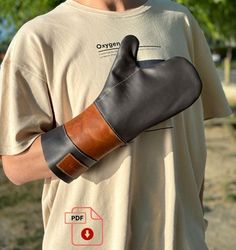 a man wearing a brown leather glove and tan t - shirt