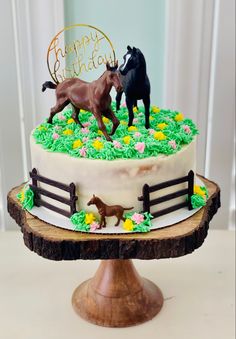 a birthday cake with two horses on top