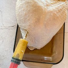 a large chicken is being prepared and put in a pan with a yellow spatula