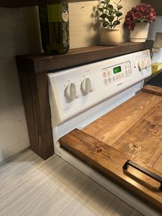 a white stove top oven sitting inside of a kitchen next to a wooden cutting board