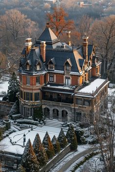 an aerial view of a mansion in the middle of winter with snow on the ground