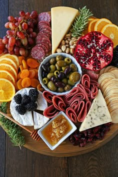 a wooden platter filled with different types of cheeses and fruit on top of it