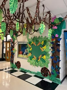 a classroom decorated with paper cut outs and leaves on the wall, along with other decorations