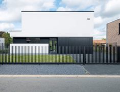 a black and white house with a fence around it