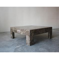 a marble coffee table sitting on top of a cement floor