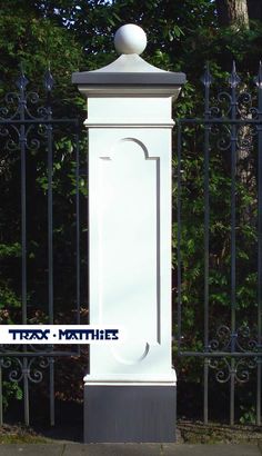 a tall white monument sitting in front of a metal fence with the words tax's mather on it