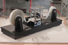 a machine that is sitting on top of a white surface with some wires attached to it