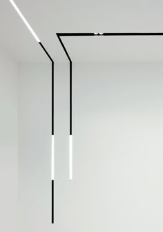 an empty room with black and white lines hanging from the ceiling in front of it