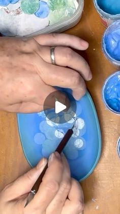 a person is painting on a blue plate