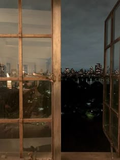 an open window looking out onto a city at night