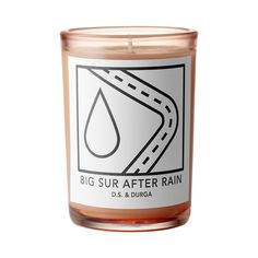 a candle with the words, big sur after rain in front of a white background