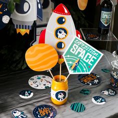 a space themed party table with rocket ship centerpieces and paper cutout decorations