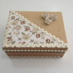 a small box with flowers and lace on it