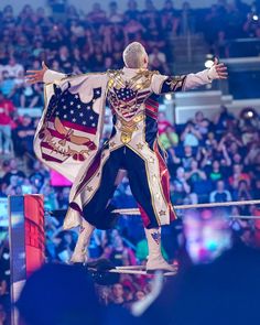 a man dressed in an american flag outfit standing on top of a wrestling ring