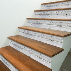 a set of wooden stairs with white painted wood treads