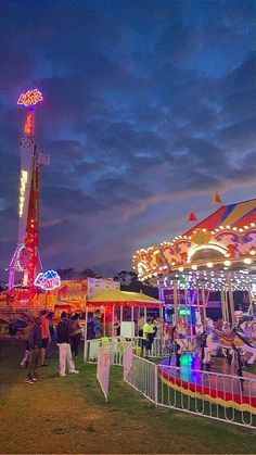 an amusement park at night with people on the rides and carousels in the background