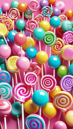 many colorful lollipops on a pink background