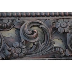 an ornate carved wood frame with flowers and leaves