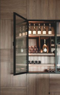 an open cabinet with many bottles and glasses