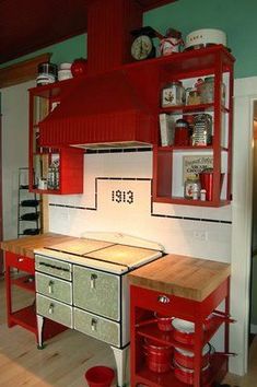 a red and white kitchen with lots of cupboards on the wall next to it