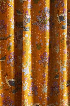 an orange curtain with birds and flowers on it