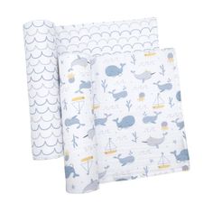 two sheets with whale print on them, one in blue and the other in white