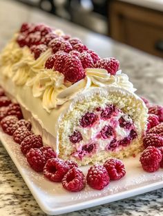 a piece of cake with white frosting and raspberries