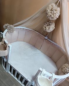 a baby crib with flowers on the top and bottom, in front of a wall