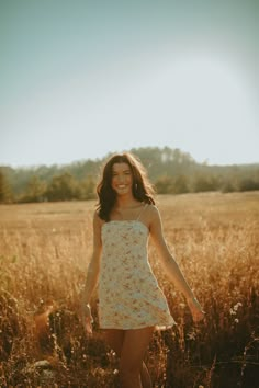 a woman is walking through the tall grass