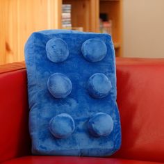 a blue pillow sitting on top of a red couch