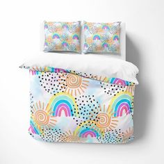 an image of a bed with rainbows and clouds on it's coverlet