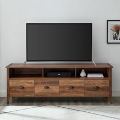 a flat screen tv sitting on top of a wooden entertainment center