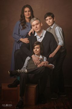 a family posing for a portrait in front of a brown background