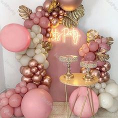 a balloon arch with pink and gold balloons