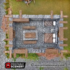 an aerial view of a stone building with two horses in the yard next to it