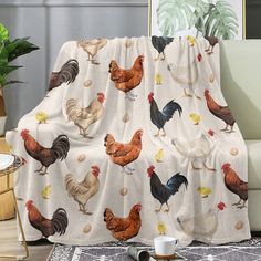 a living room with a couch covered in a chicken blanket and coffee cup on the floor