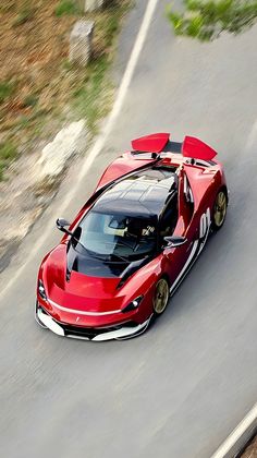 a red sports car driving down the road