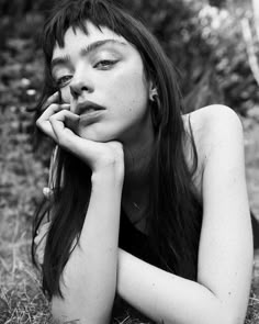 a woman laying on the ground with her hand under her chin