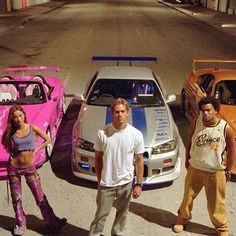 three men and two women standing in front of cars with the words sempreunica on it