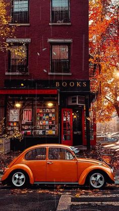 an orange car parked in front of a book store