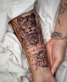 a woman's arm with a tiger and flowers tattoo on it