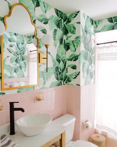 a bathroom with pink and green wall paper