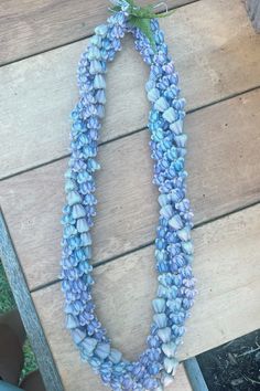 a blue and white necklace sitting on top of a wooden table