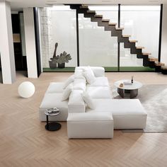 a large white couch sitting on top of a wooden floor next to a stair case