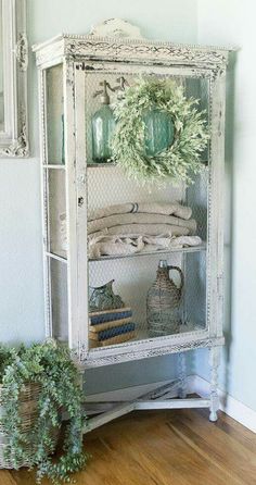 an old china cabinet is decorated with greenery