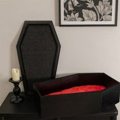 a black table with a red blanket on it and a white candle next to it