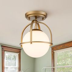 a light that is hanging from the ceiling in a room with green walls and windows