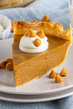 a slice of pumpkin pie on a plate with whipped cream and caramel garnish