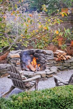 an outdoor fire pit with chairs around it